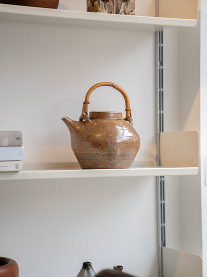 A salt glazed studio pottery teapot and cover with bamboo swing handle by  Sarah Walton (UK) 1970s