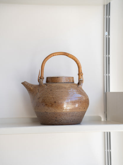 A salt glazed studio pottery teapot and cover with bamboo swing handle by  Sarah Walton (UK) 1970s