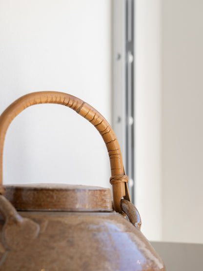 A salt glazed studio pottery teapot and cover with bamboo swing handle by  Sarah Walton (UK) 1970s